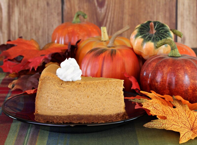 Slice of Paleo Pumpkin Pie on Black Plate Beside Arrangement of Fall Leaves, Pumpkins and Gourds | Vitacost.com/blog
