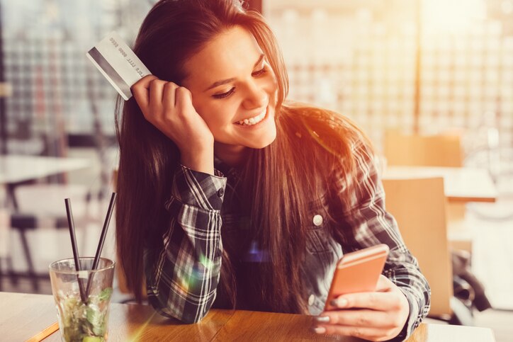 Girl shopping on her mobile phone and saving money online
