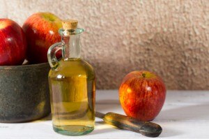 apple cider vinegar, apples and knife on table