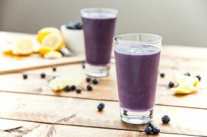 2 Glasses Full of This Blueberry Smoothie Recipe on Wood Table With Fresh Blueberries | Vitacost.com/blog