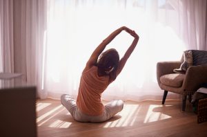 Woman Stretching to Complete Hotel Room Workout | Vitacost.com/blog