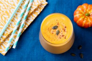 Pumpkin Pie Smoothie on Royal Blue Tablecloth with Pumpkin Prop and Teal Straws | Vitacost.com/blog