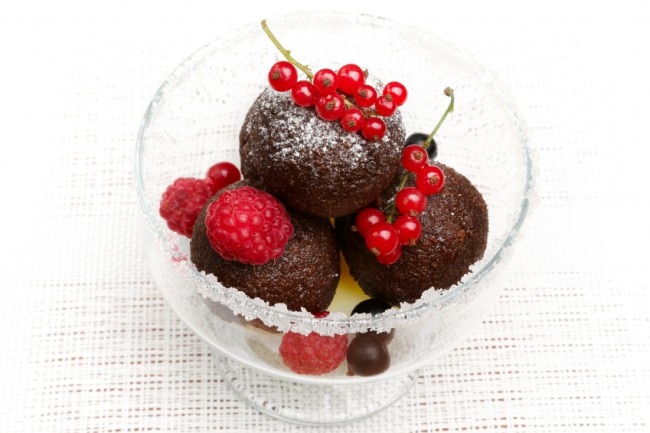 Cacao, Raspberry & Pomegranate Cake Bites Chocolate cake bites with berries in a glass bowl