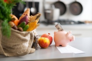 Bag of groceries on counter with a piggy bank