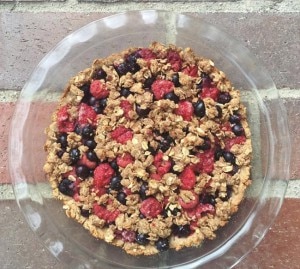 Blueberry and raspberry oat crumble in a glass pie dish