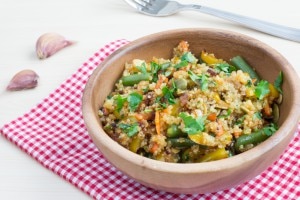 Stir-fried vegetables and quinoa in bowl with red checkered napkin