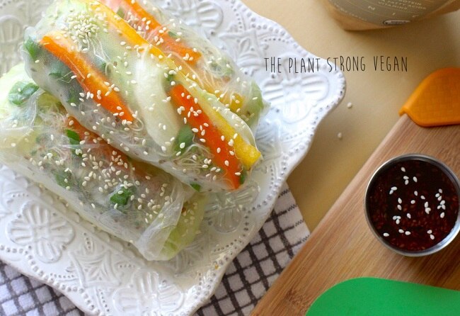 Vegetable spring rolls on a white plate with peanut sauce