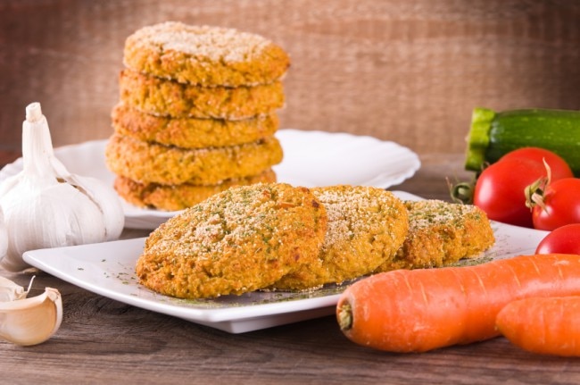 Veggie burgers on white plate with vegetables