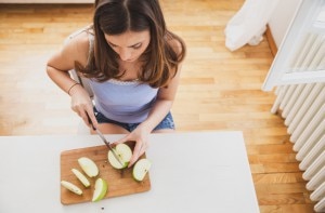 Woman Cutting Apple to Follow Anti-Inflammatory Diet www.vitacost.com/blog