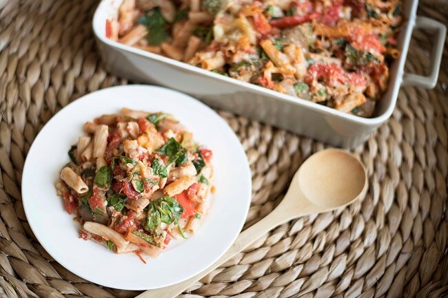 Chicken penne pasta on white plate with wooden spoon #recipe | www.vitacost.com/blog