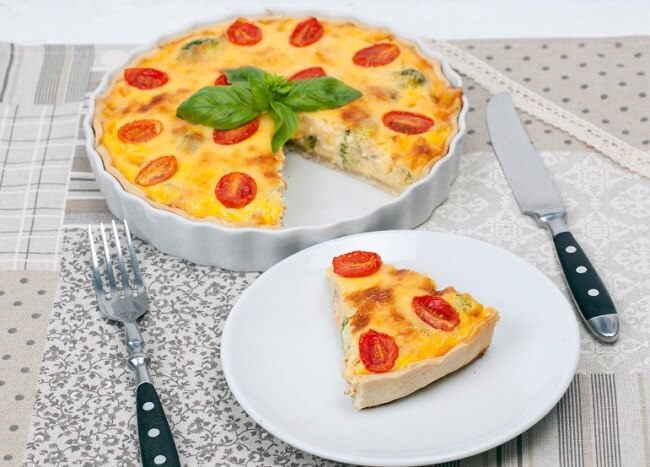 Slice and whole pie of corn quiche with sliced tomatoes #restinquiche www.vitacost.com/blog
