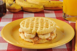 Banana and peanut butter on gluten-free waffle sandwich on yellow plate #healthybreakfast www.vitacost.com/blog