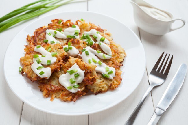 Spiced Potato Hash Browns Recipe  Potato hash browns with sour cream on a white plate with chives #healthybreakfast www.vitacost.com/blog
