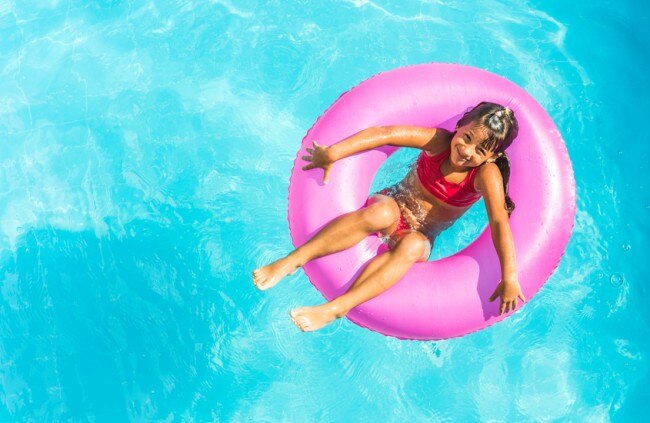 4 Ways to Soothe Sunburn in Children Girl in Inner Tube Swimming in Pool www.vitacost.com/blog