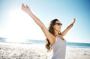 Woman With Outstretched Arms at the Beach Following Summer Tips | www.vitacost.com/blog