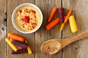 Roasted red pepper hummus with rainbow carrots on wood | www.vitacost.com/blog