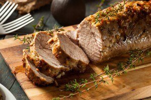 Sliced pan-seared pork loin on wood with herbs #paleo #recipe | www.vitacost.com/blog