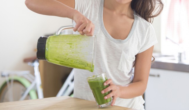 Woman Pouring Green Smoothie From Blender Trying New Diet Trends | www.vitacost.com/blog