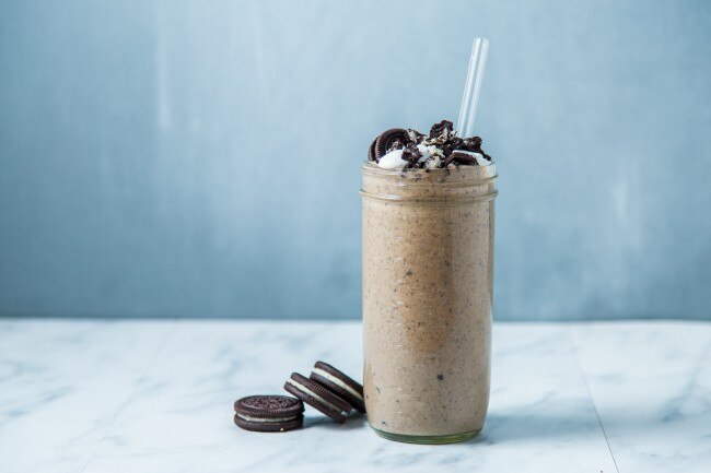 Chocolate cookie protein shake in tall Mason jar with straw & cookies | www.vitacost.com/blog