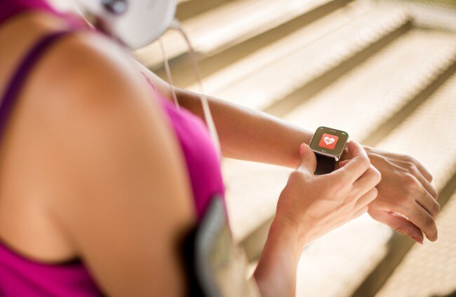 Getting in Shape Without Breaking the Bank Woman Checking Fitness Gadget During Workout Routine | www.vitacost.com/blog