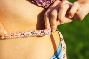 Woman Trying to Lose Belly Fat Measuring Waistline | www.vitacost.com/blog