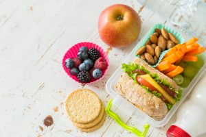 A healthy, homemade school lunch of berries, crackers, almonds, grapes, carrots, apple and a sandwich | Vitacost.com/Blog