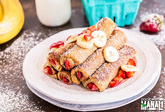 French Toast Roll-Ups on a Plate Stuffed with Strawberries and Bananas with Powdered Sugar on Top | Blog.Vitacost.com