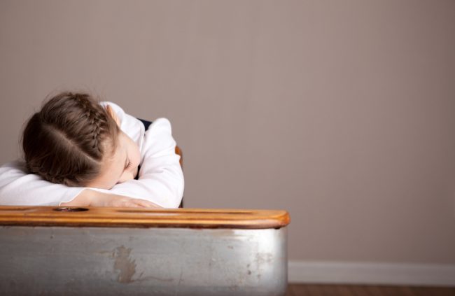 Child Suffering Sleep Deprivation With Head on Desk at School | Vitacost.com/blog
