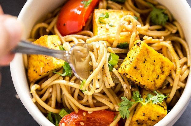 Soba Noodles with Curry-Spiced Tofu Curry-Spiced Tofu and Soba Noodles in a bowl with red bell pepper, green onions, cilantro and sesame seeds | Vitacost.com/Blog