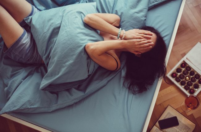 Busy Mom Covering Face in Bed Because She's Stressed Out | Vitacost.com/blog