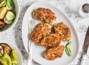 Quinoa-Crusted Chicken Tenders on White Plate with Veggie Bowls | Vitacost.com/blog