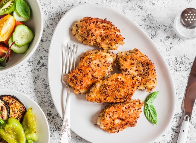 Quinoa-Crusted Chicken Tenders on White Plate with Veggie Bowls | Vitacost.com/blog