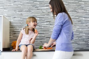 Mother Concerned About Omegas for Kids Preparing Food for Child Sitting on Counter | Vitacost.com/blog