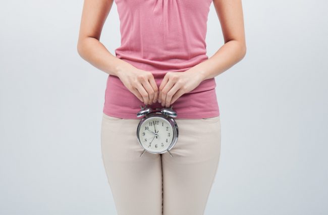 Woman Waiting for Period Holding Clock | Vitacost.com/blog