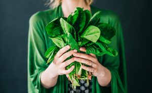 Woman Holding Bunch of Magnesium-Rich Leafy Green Spinach | Vitacost.com/blog