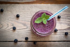 Paleo-friendly blueberry-avocado smoothie in a glass jar with a straw | Vitacost.com/Blog