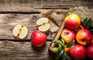 Immune-Boosting Red Apples Scattered on Wooden Table | Vitacost.com/blog