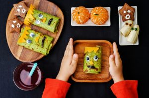 Child's hands holding plate with healthy Halloween treats | Vitacost.com/Blog