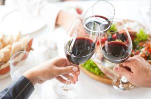 Party Guests Hoping Not to Need Hangover Remedies Cheersing With Wine Glasses | Vitacost.com/blog