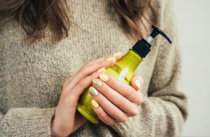 Woman Following Winter Skin Care Tips Holding Bottle of Lotion | Vitacost.com/blog