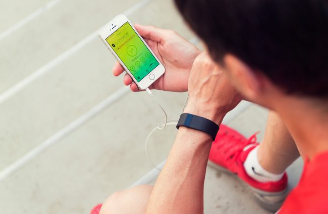 Fitness Tracking: Are Pricey Devices Worth It? Man Checking Fitness Tracking Wristband Device During Exercise | Vitacost.com/blog