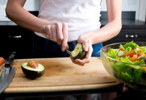 Woman Cutting Avocado for Healthy Fats in Her Salad #weightloss | Vitacost.com/blog