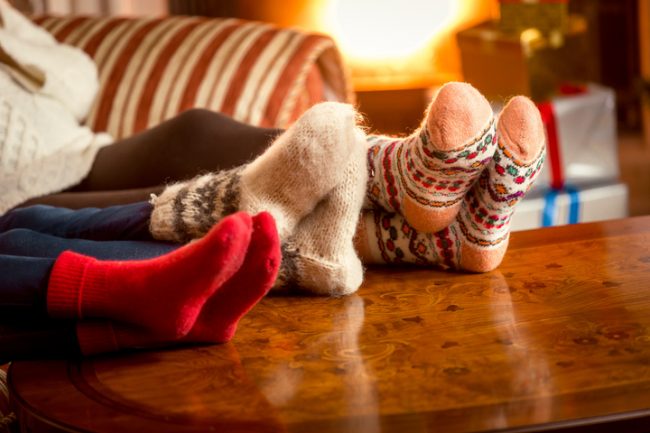 Holiday Stress: Tips for Coping With Common Struggles of the Season Family Tackling Holiday Stress and Anxiety by Relacing with Feet Up on Table | Vitacost.com/blog
