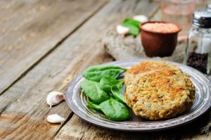 Vegan lentil-oat burger on plate with spinach | Vitacost.com/blog