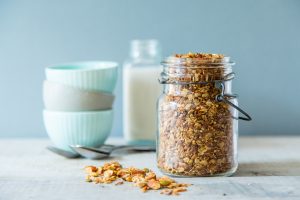 Jar of Homemade Protein Granola with Bowls & Spoons #vegan | Vitacost.com/blog