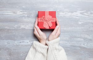 Woman Being Generous Holding Red Gift Box in Hands | Vitacost.com/blog