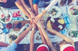 Friends Huddle at Potluck Party Table During the Holidays | Vitacost.com/blog