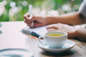 Woman Drinks Tea & Journals for Stress Relief | Vitacost.com/blog