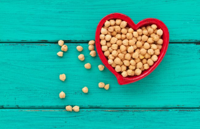 Heart Shaped Bowl Filled With Chickpeas on Teal Wood Table | Vitacost.com/blog