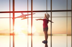 Girl Traveling Watching Plane Through Airport Window | Vitacost.com/Blog